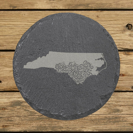 North Carolina round slate coaster engraved with the state shape in ornate floral scrollwork