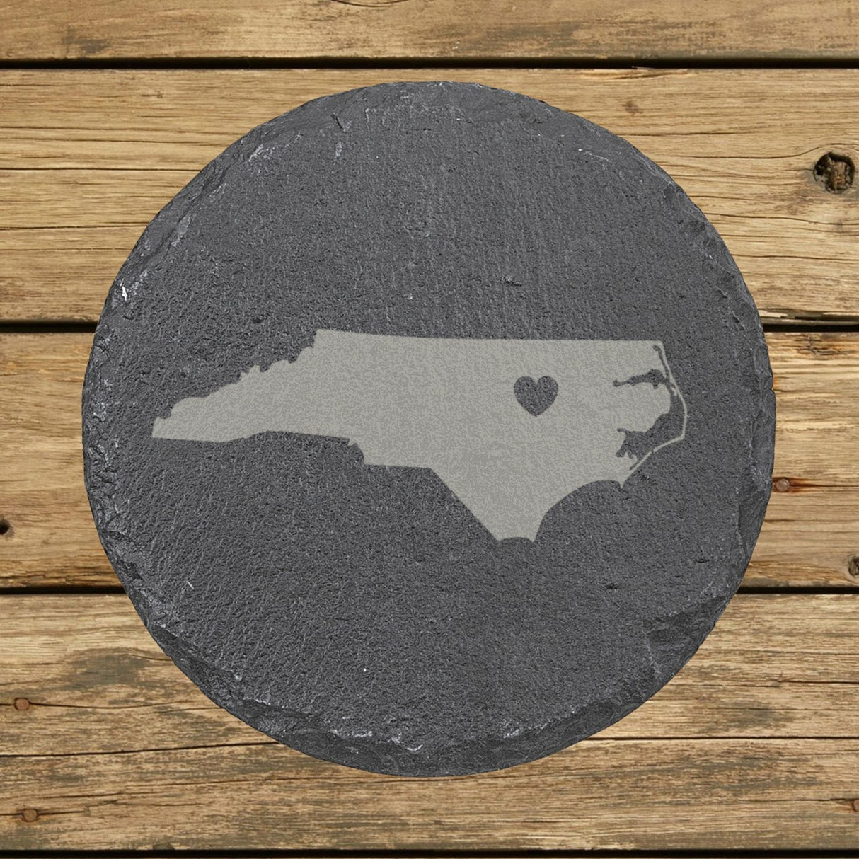 North Carolina round slate coaster engraved with the state shape and a heart