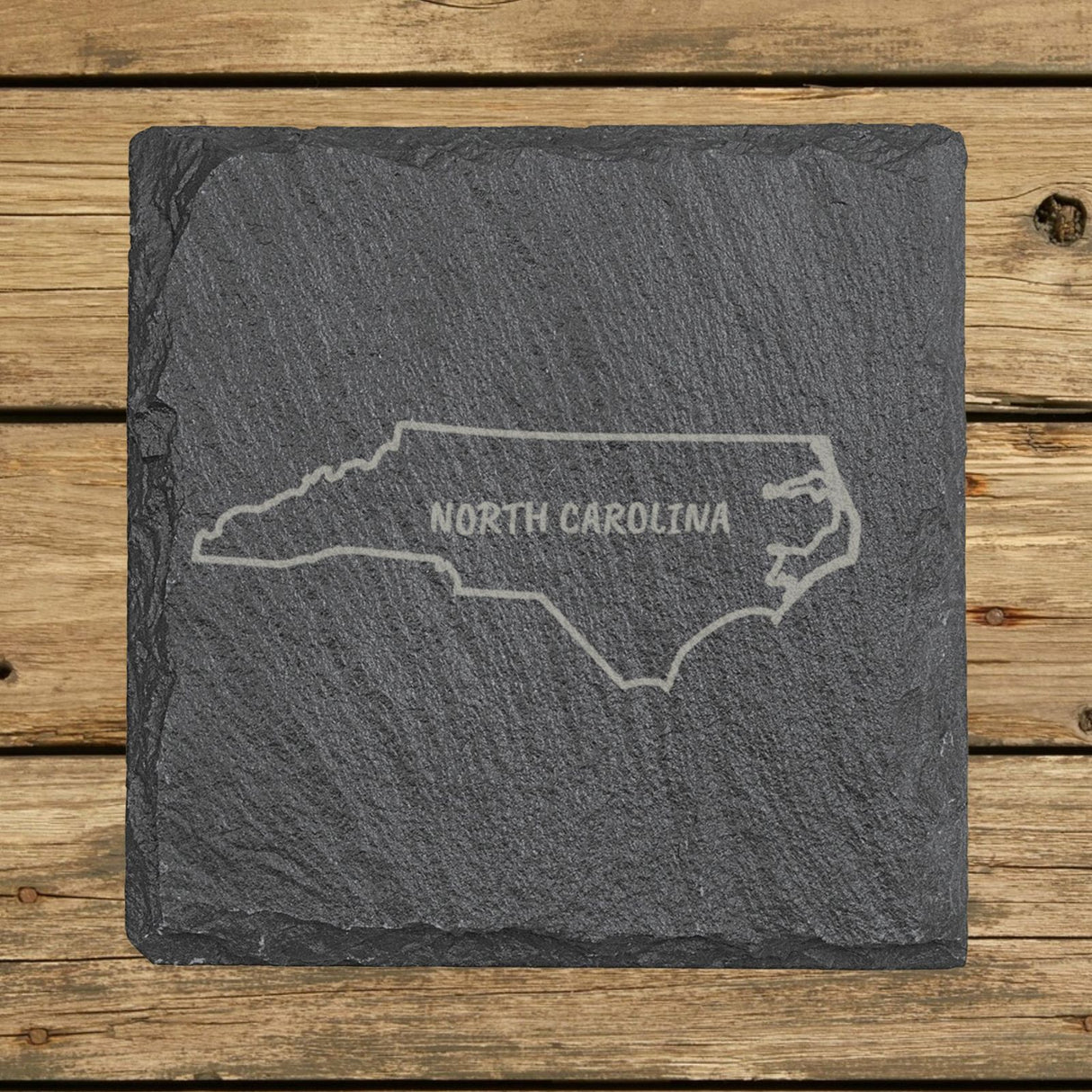 North Carolina square slate coaster engraved with the state outline and NORTH CAROLINA in hand-drawn brush lettering