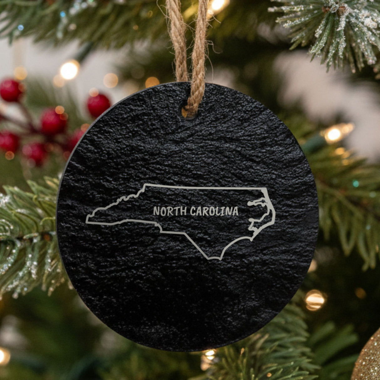 North Carolina slate Christmas ornament engraved with the state outline and NORTH CAROLINA in hand-drawn brush lettering