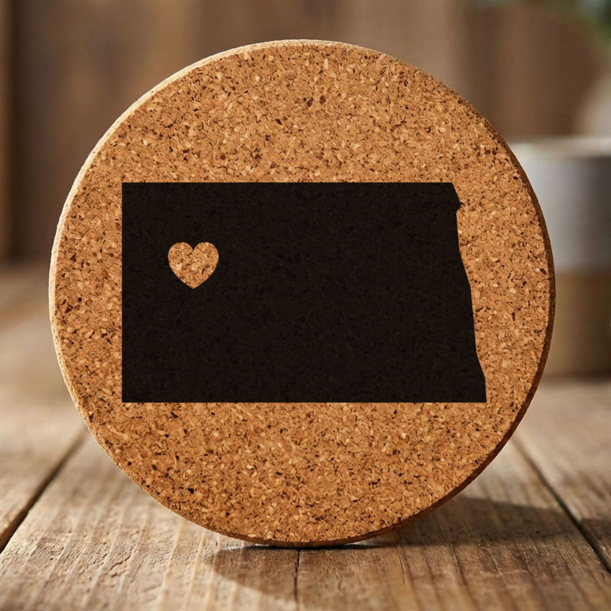 North Dakota round cork coaster engraved with the state shape and a heart