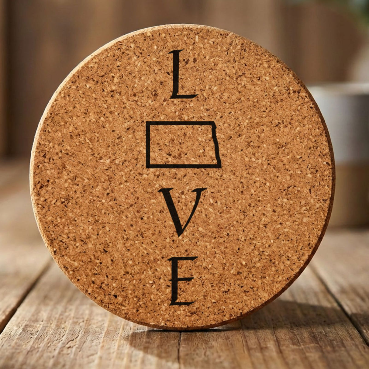 North Dakota round cork coaster engraved with LOVE stacked vertically using the state as the letter O