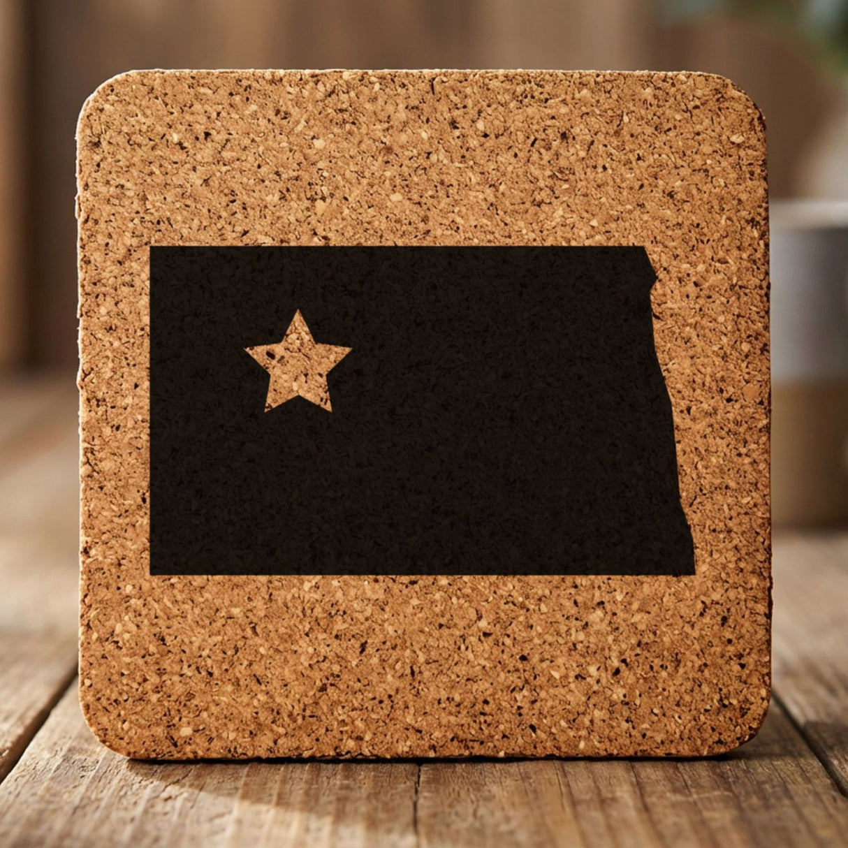 North Dakota square cork coaster engraved with the state shape and a star