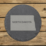 North Dakota round slate coaster engraved with the state shape and NORTH DAKOTA in bold lettering