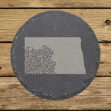 North Dakota round slate coaster engraved with the state shape in ornate floral scrollwork