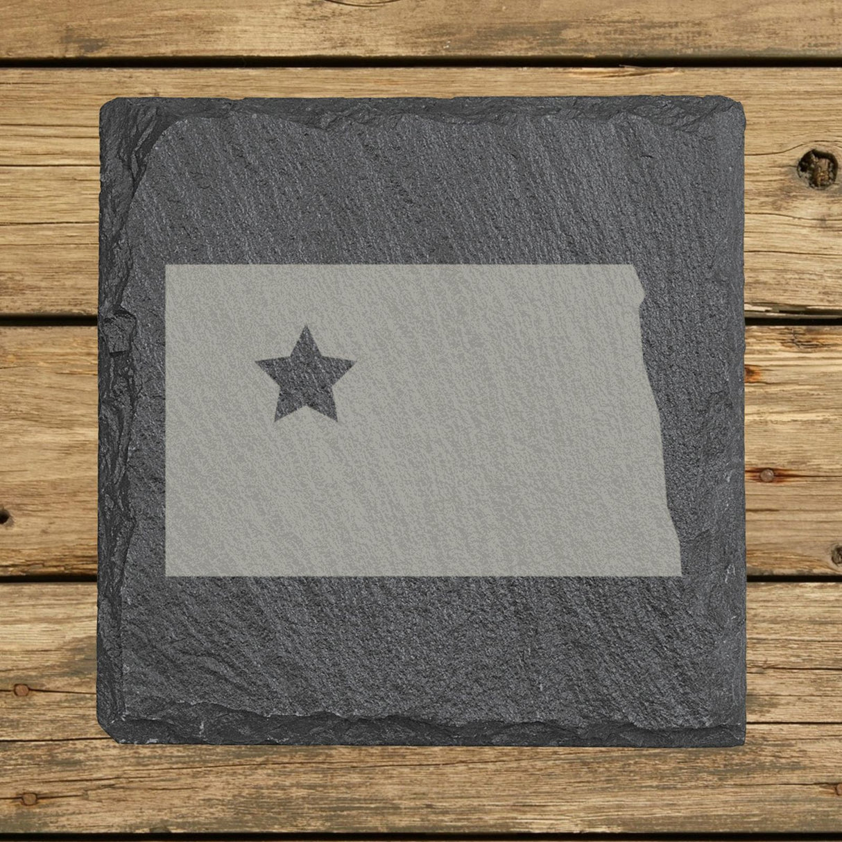 North Dakota square slate coaster engraved with the state shape and a star