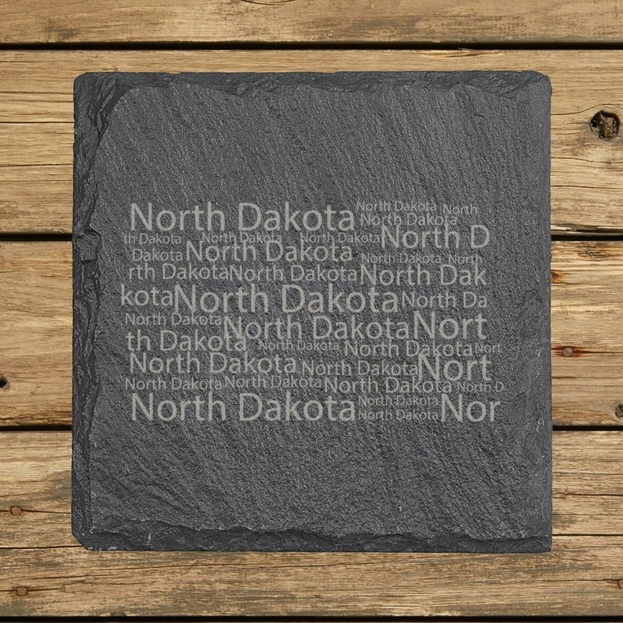 North Dakota square slate coaster engraved with a word cloud of repeating North Dakota text