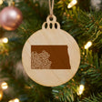 North Dakota round wood Christmas ornament engraved with the state shape in ornate floral scrollwork