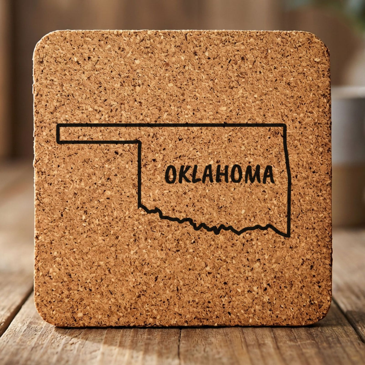 Oklahoma square cork coaster engraved with the state outline and OKLAHOMA in hand-drawn brush lettering