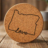 Oregon round cork coaster engraved with a hand-drawn state outline and love in cursive