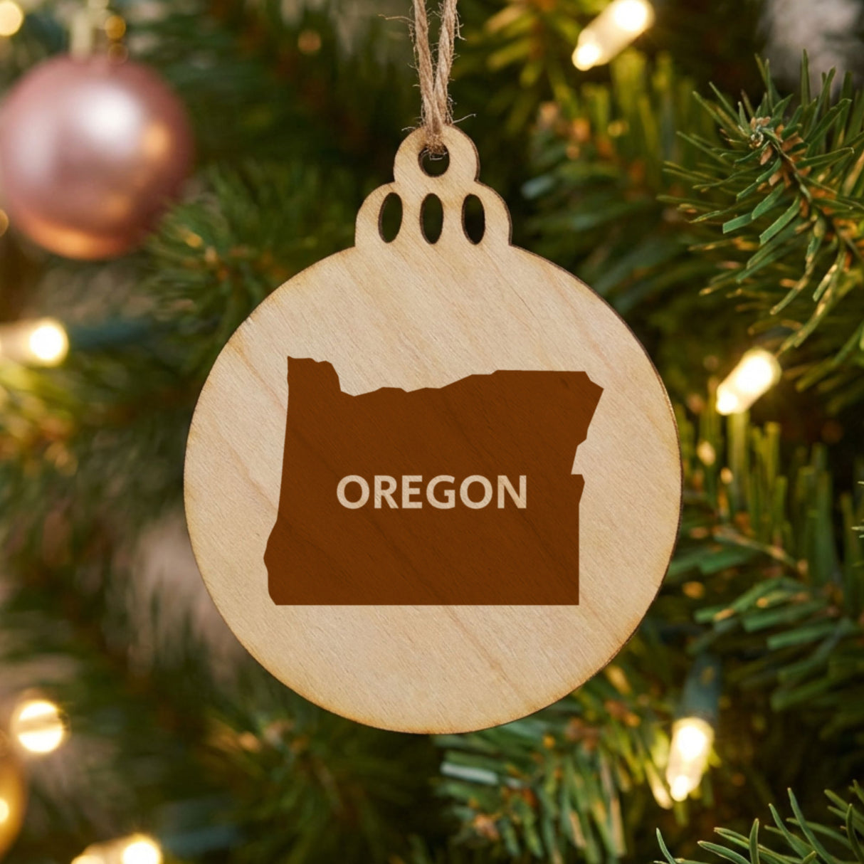 Oregon round wood Christmas ornament engraved with the state shape and OREGON in bold lettering