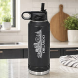 Black 32 oz insulated water bottle laser engraved with the Orlando, Florida skyline running up the side, standing on a kitchen counter