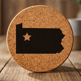 Pennsylvania round cork coaster engraved with the state shape and a star