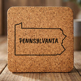 Pennsylvania square cork coaster engraved with the state outline and PENNSYLVANIA in hand-drawn brush lettering