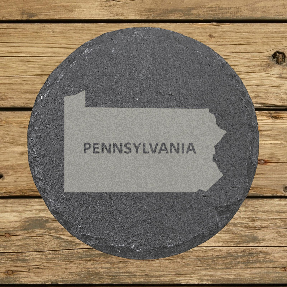 Pennsylvania round slate coaster engraved with the state shape and PENNSYLVANIA in bold lettering