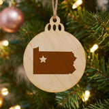 Pennsylvania round wood Christmas ornament engraved with the state shape and a star