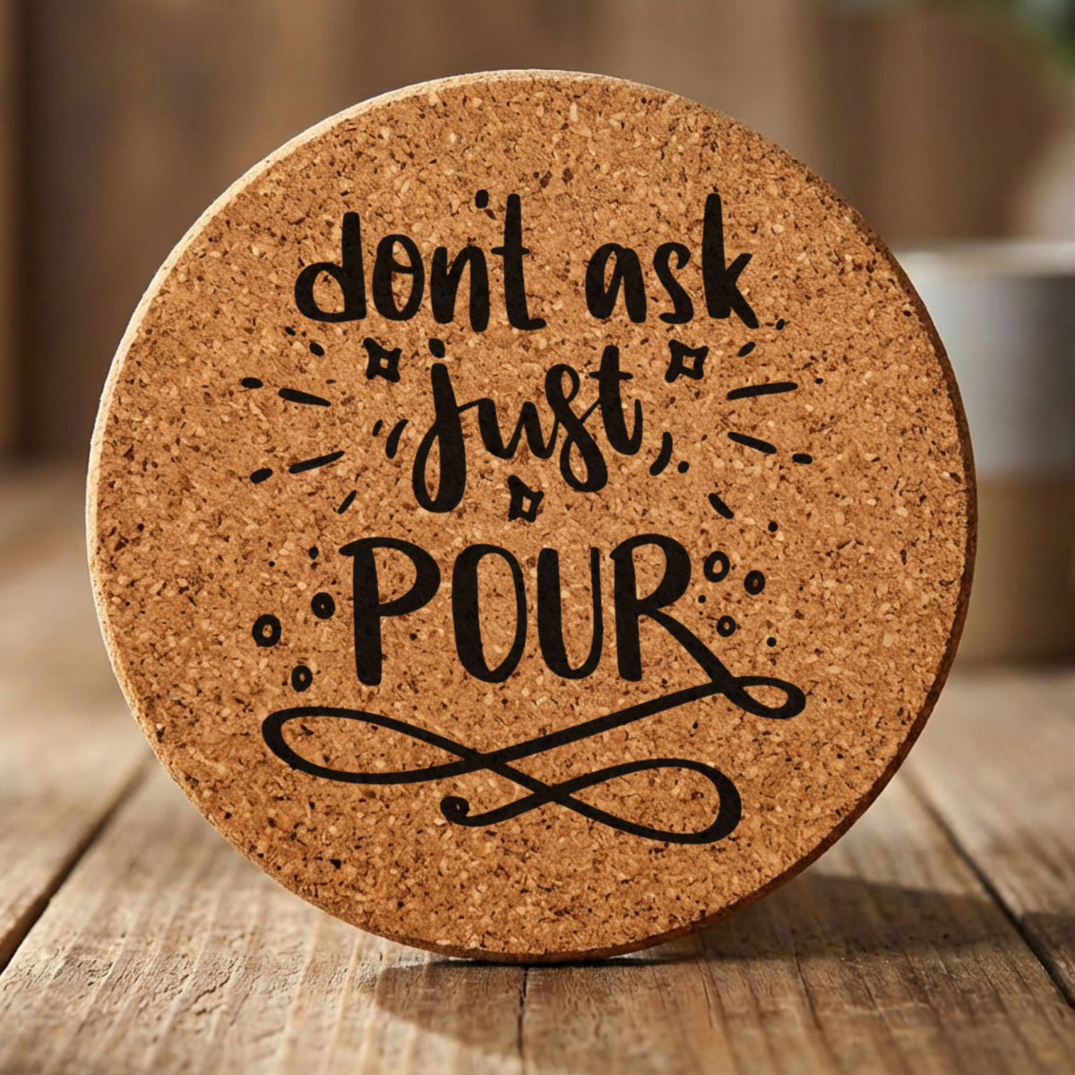 Round cork coaster laser engraved with "Don't Ask, Just Pour", hand lettered design