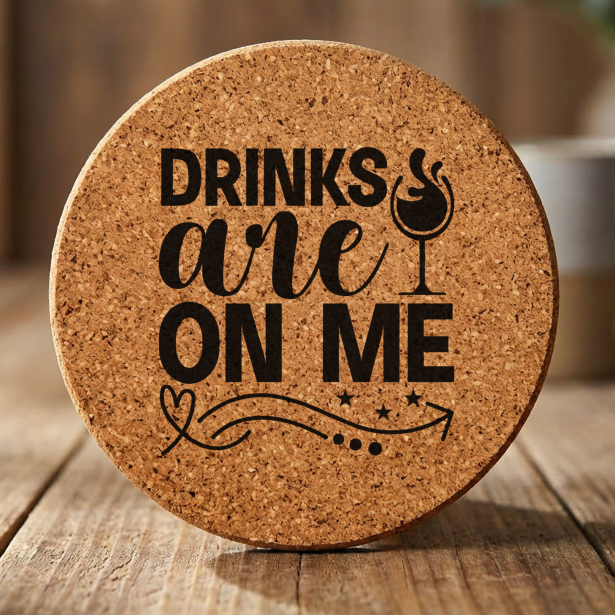 Round cork coaster laser engraved with "Drinks Are On Me", wine glass design