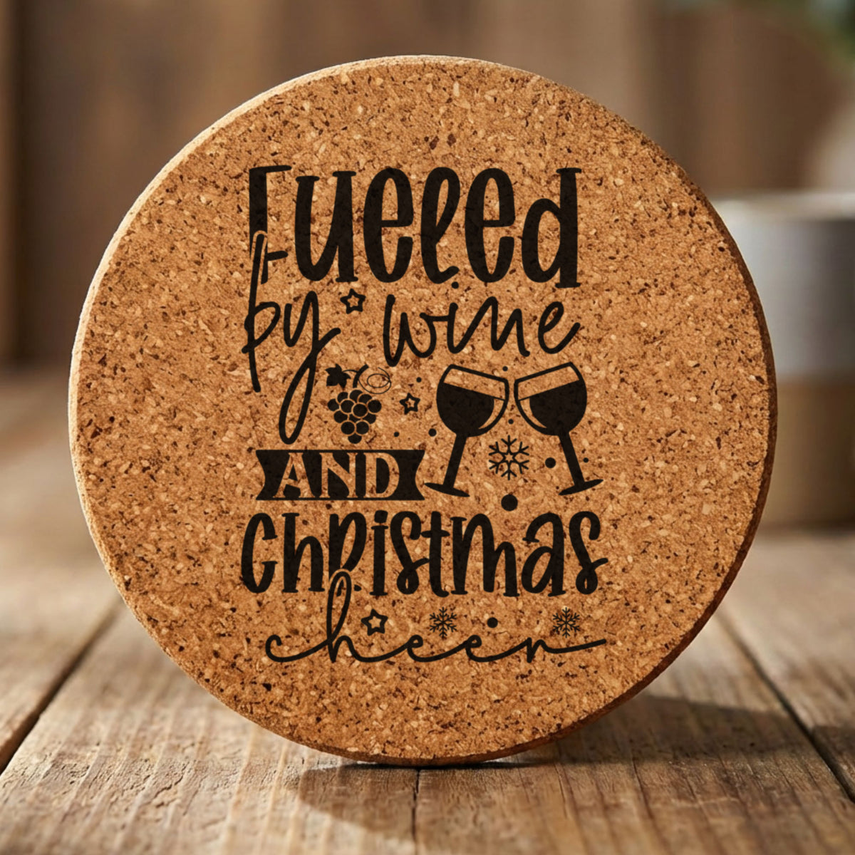 Round cork coaster laser engraved with "Fueled by Wine and Christmas Cheer"
