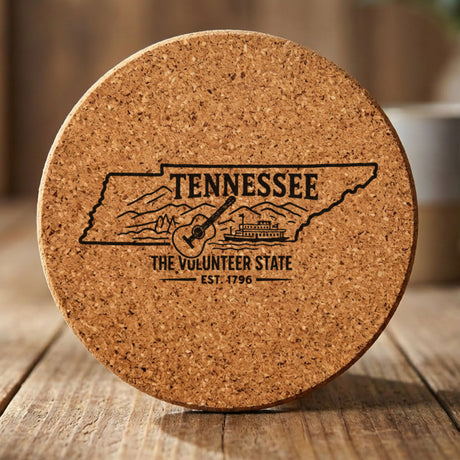Tennessee round cork coaster engraved with the state outline, a guitar, a riverboat and the Smoky Mountains, "The Volunteer State"