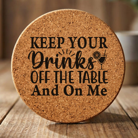 Round cork coaster laser engraved with "Keep Your Drinks Off the Table and On Me"