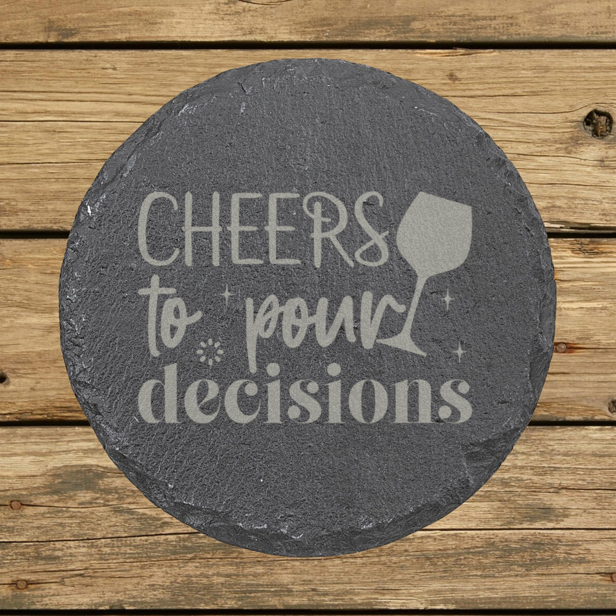 Round slate coaster laser engraved with "Cheers to Pour Decisions"