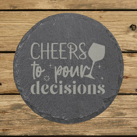 Round slate coaster laser engraved with "Cheers to Pour Decisions"