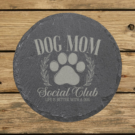Round slate coaster laser engraved with a Dog Mom Social Club crest design with a paw print and laurel wreath