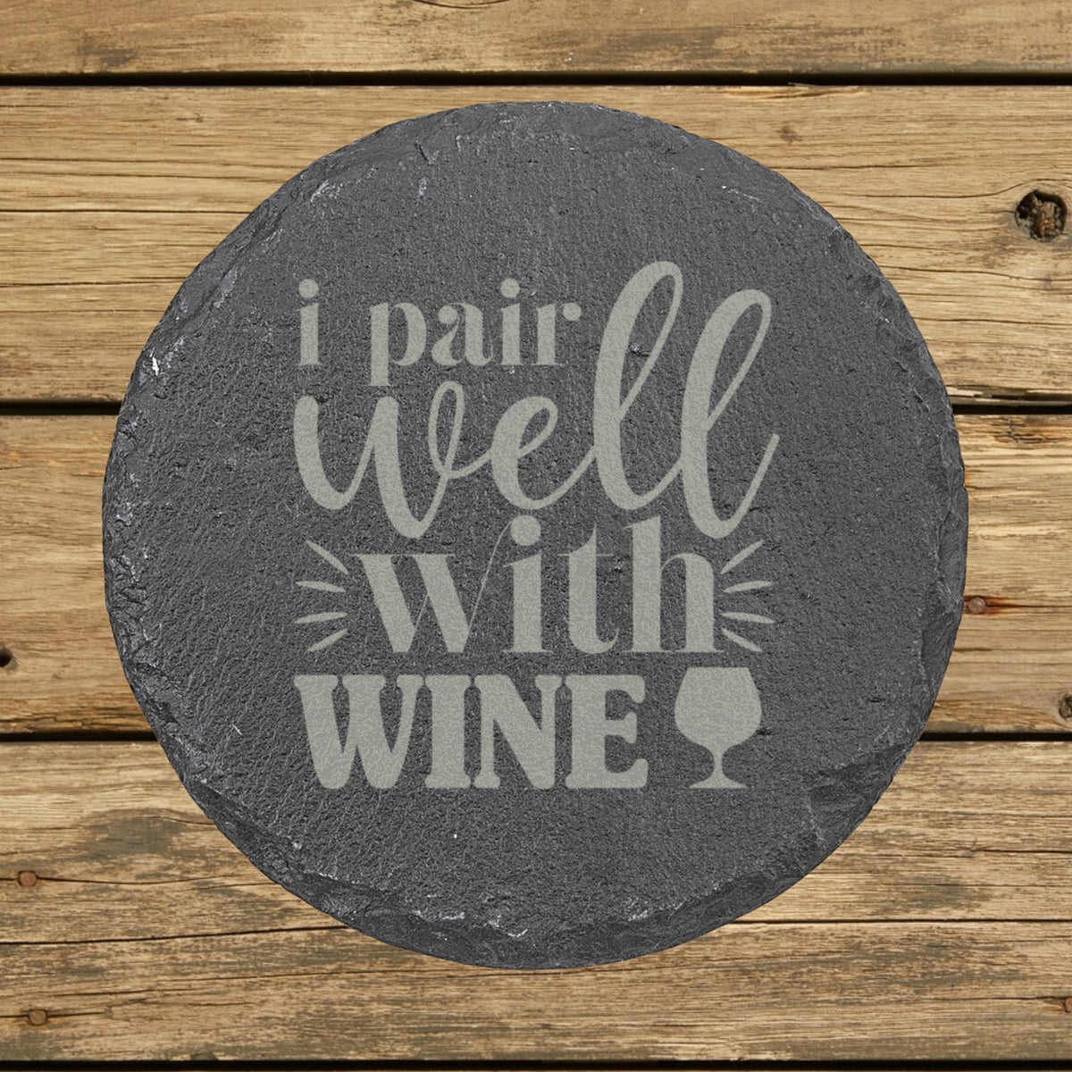 Round slate coaster laser engraved with "I Pair Well with Wine"