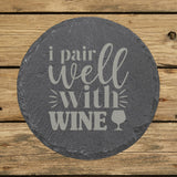 Round slate coaster laser engraved with "I Pair Well with Wine"