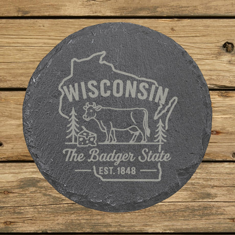 Wisconsin round slate coaster engraved with the state outline, a dairy cow and a wedge of cheese, "The Badger State"