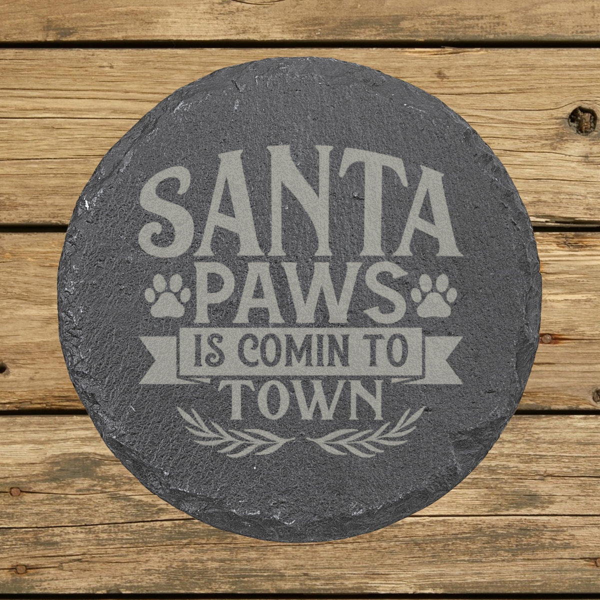 Round slate coaster laser engraved with "Santa Paws Is Comin' to Town"