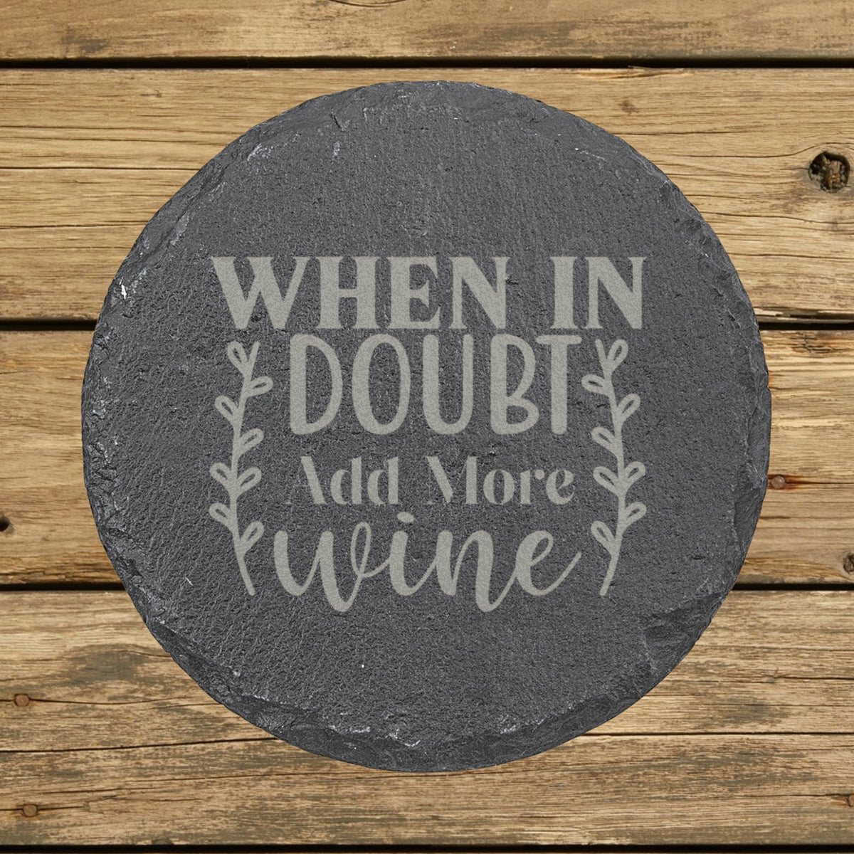Round slate coaster laser engraved with "When in Doubt, Add More Wine", wreath design
