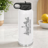 White 32 oz insulated water bottle laser engraved with the San Antonio, Texas skyline running up the side, standing on a kitchen counter