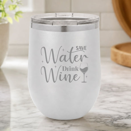 White 12 oz stemless wine tumbler laser engraved with "Save Water, Drink Wine", on a kitchen counter