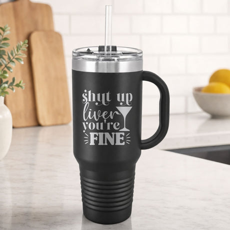 Black 40 oz tumbler with handle and straw laser engraved with "Shut Up Liver, You're Fine", on a kitchen counter