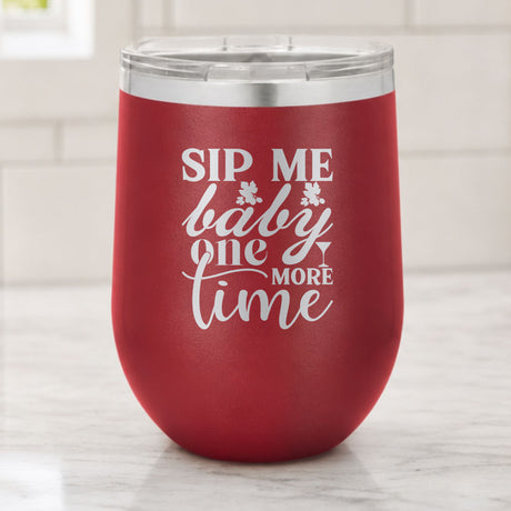 Maroon 12 oz stemless wine tumbler laser engraved with "Sip Me Baby One More Time", on a kitchen counter