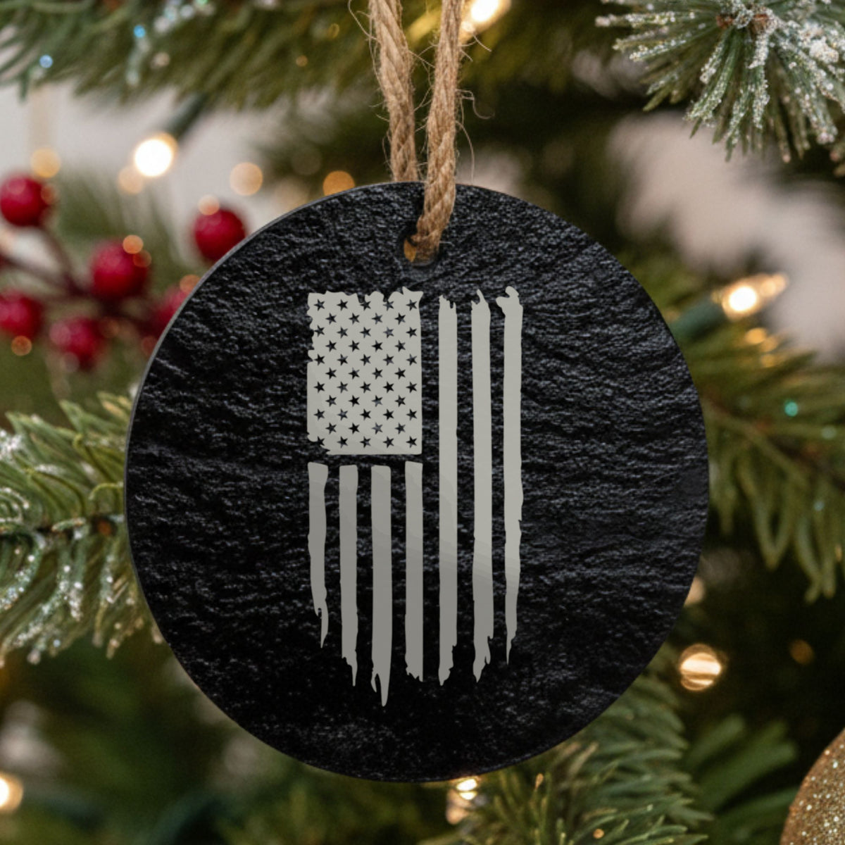 Round black slate Christmas ornament laser engraved with an American flag, distressed vertical design