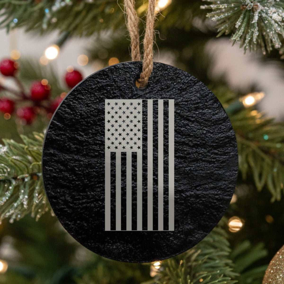 Round black slate Christmas ornament laser engraved with an American flag, vertical design