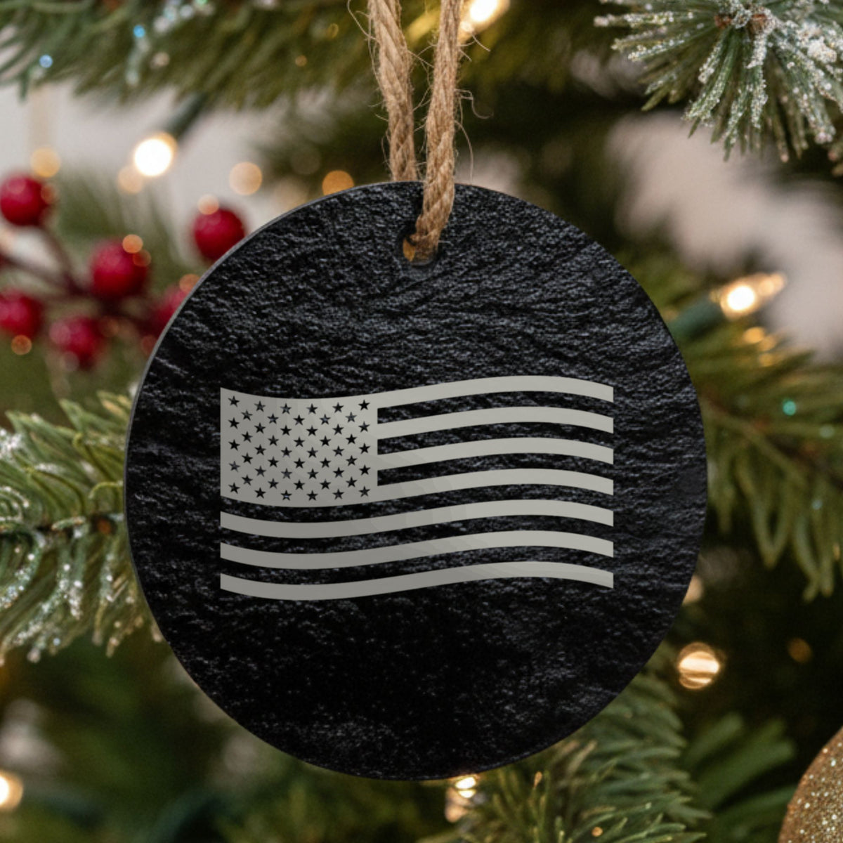 Round black slate Christmas ornament laser engraved with an American flag, waving design