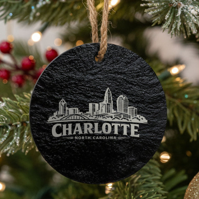 Charlotte, North Carolina skyline engraved on a round slate Christmas ornament