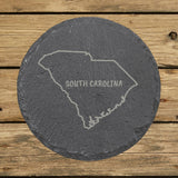 South Carolina round slate coaster engraved with the state outline and SOUTH CAROLINA in hand-drawn brush lettering