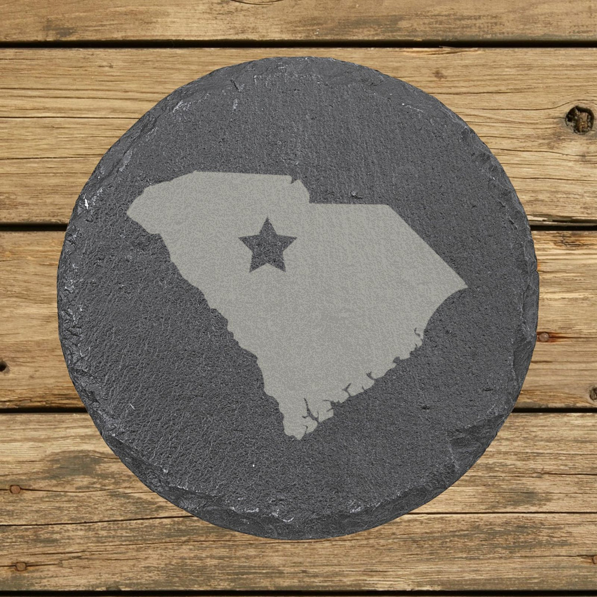 South Carolina round slate coaster engraved with the state shape and a star