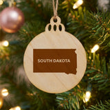 South Dakota round wood Christmas ornament engraved with the state shape and SOUTH DAKOTA in bold lettering
