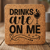 Square cork coaster laser engraved with "Drinks Are On Me", wine glass design