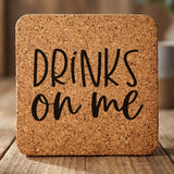 Square cork coaster laser engraved with "Drinks On Me"