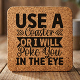 Square cork coaster laser engraved with "Use a Coaster or I Will Poke You in the Eye", hand lettered design