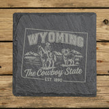 Wyoming square slate coaster engraved with the state outline, a cowboy on horseback, a bighorn sheep and mountains, "The Cowboy State"