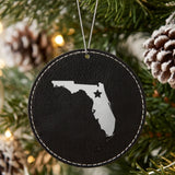 Black leatherette round Christmas ornament laser engraved with the Florida Star Accent design, hanging on a tree