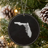 Black leatherette round Christmas ornament laser engraved with the Florida Floral Damask design, hanging on a tree